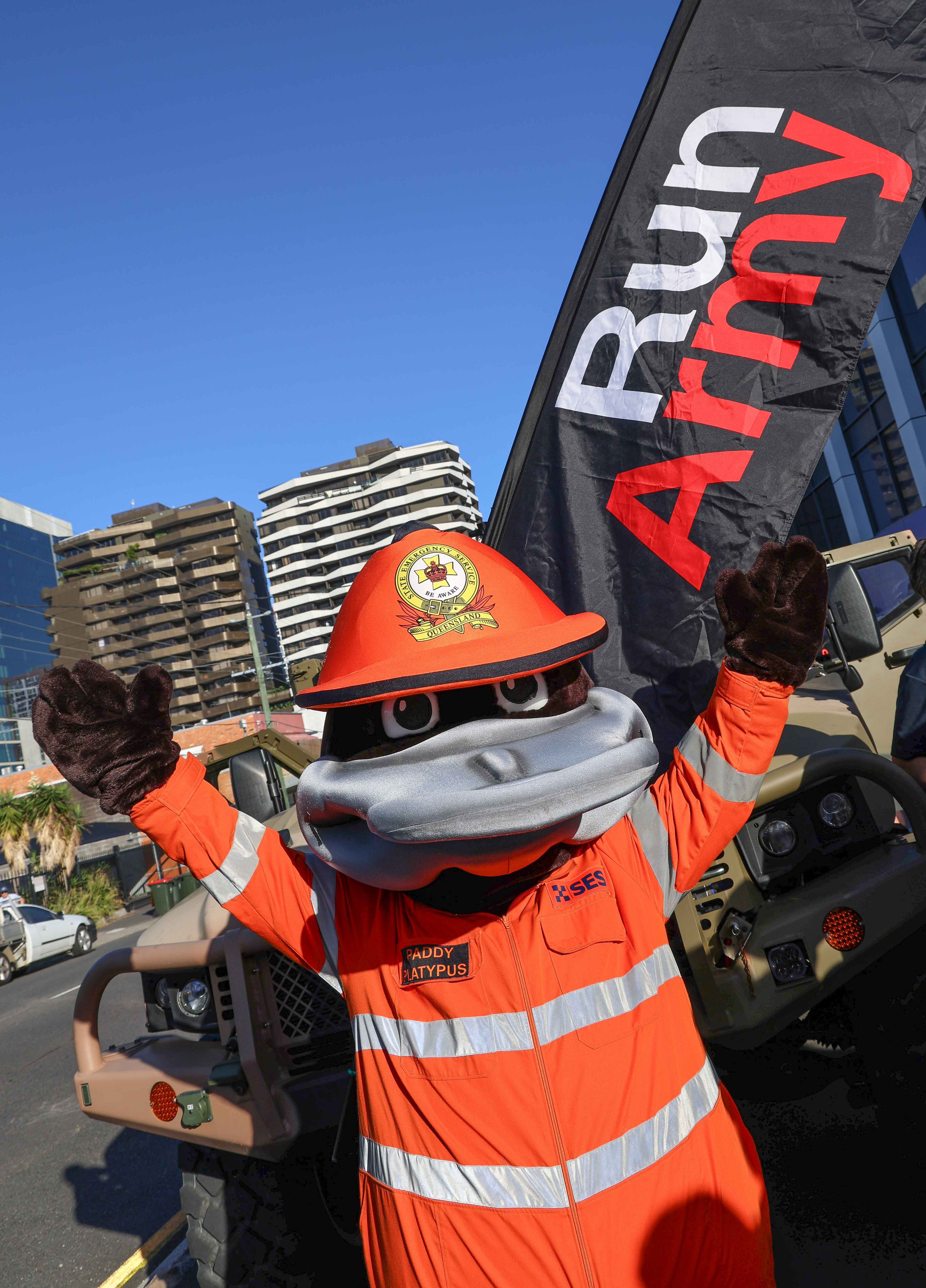 Paddy the platypus standing in front of Run Army flag