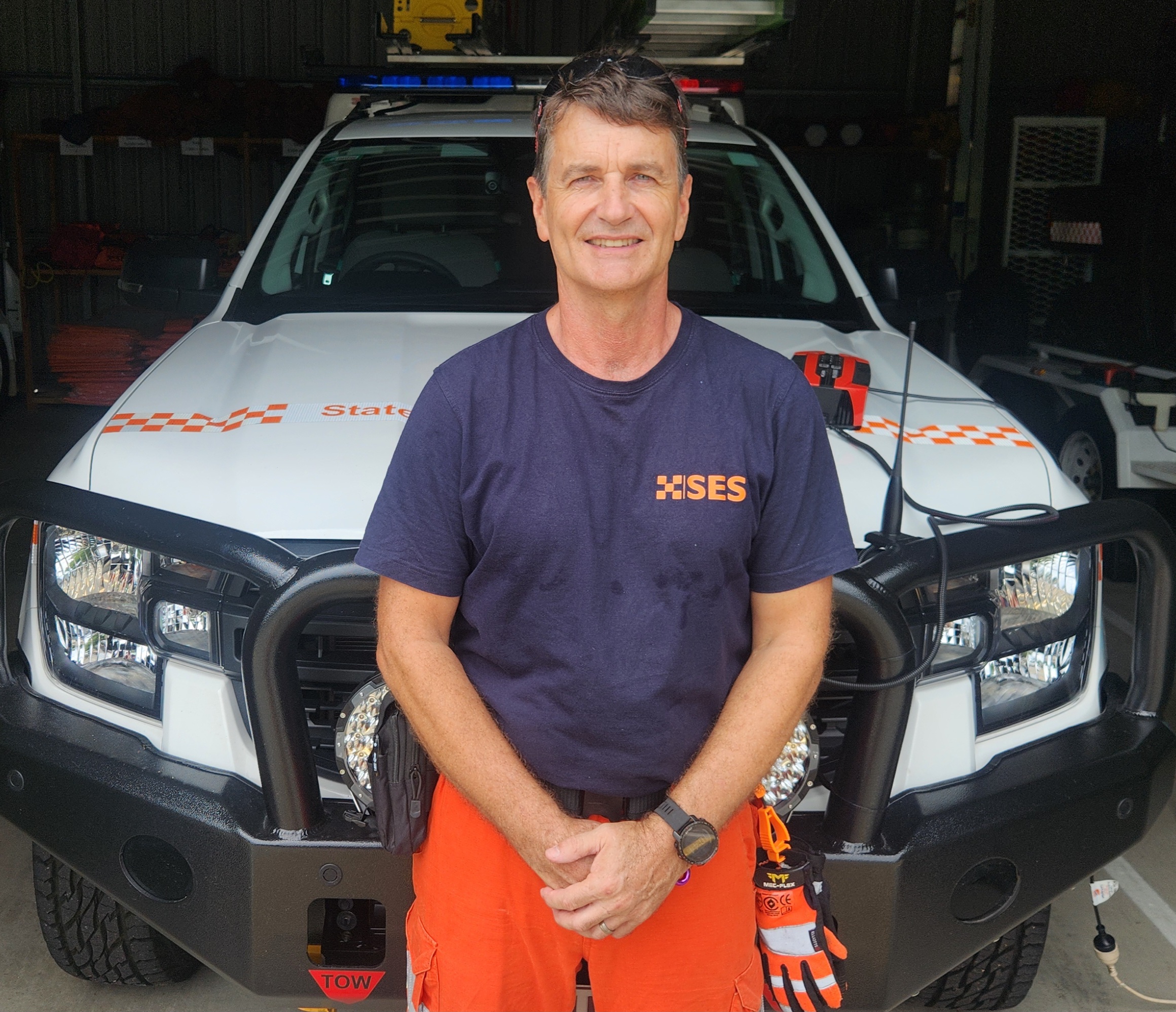 SES Volunteer leaning against SES vehicle.