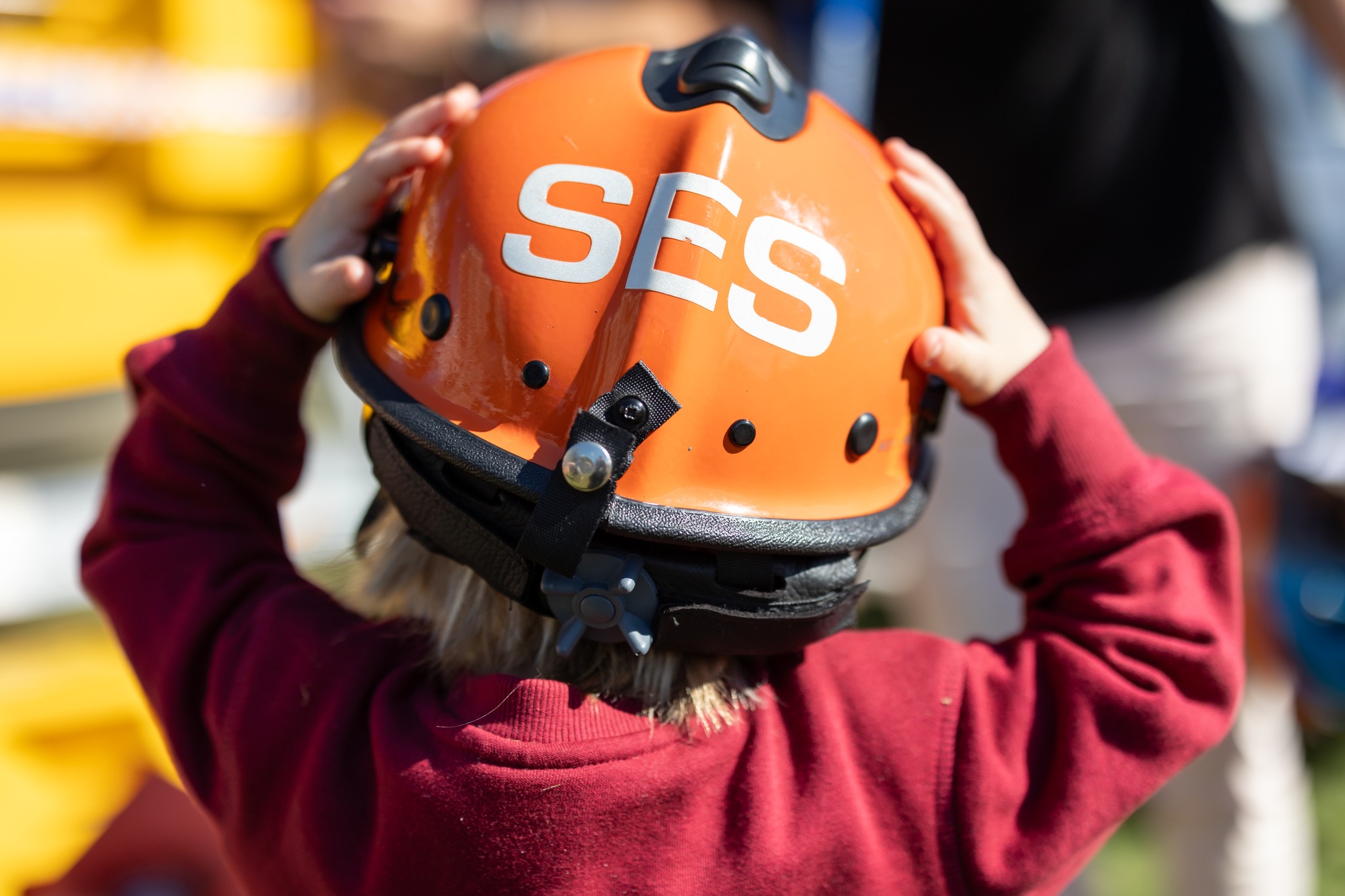 Child with SES helmet on. Portrait height facing away from camera looking at the back of the helmet.