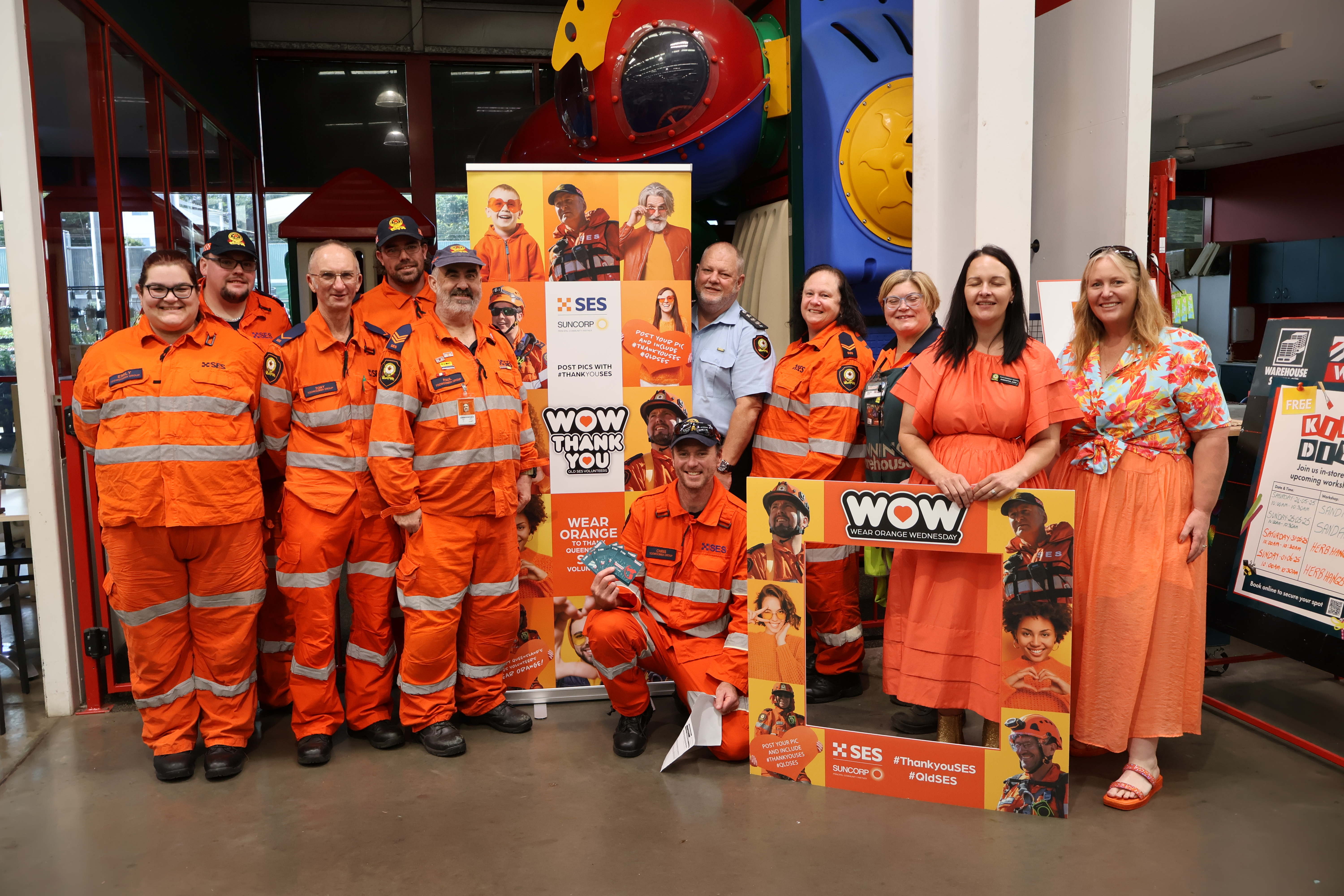 Group of SES volunteers and community standing in front of a banner.