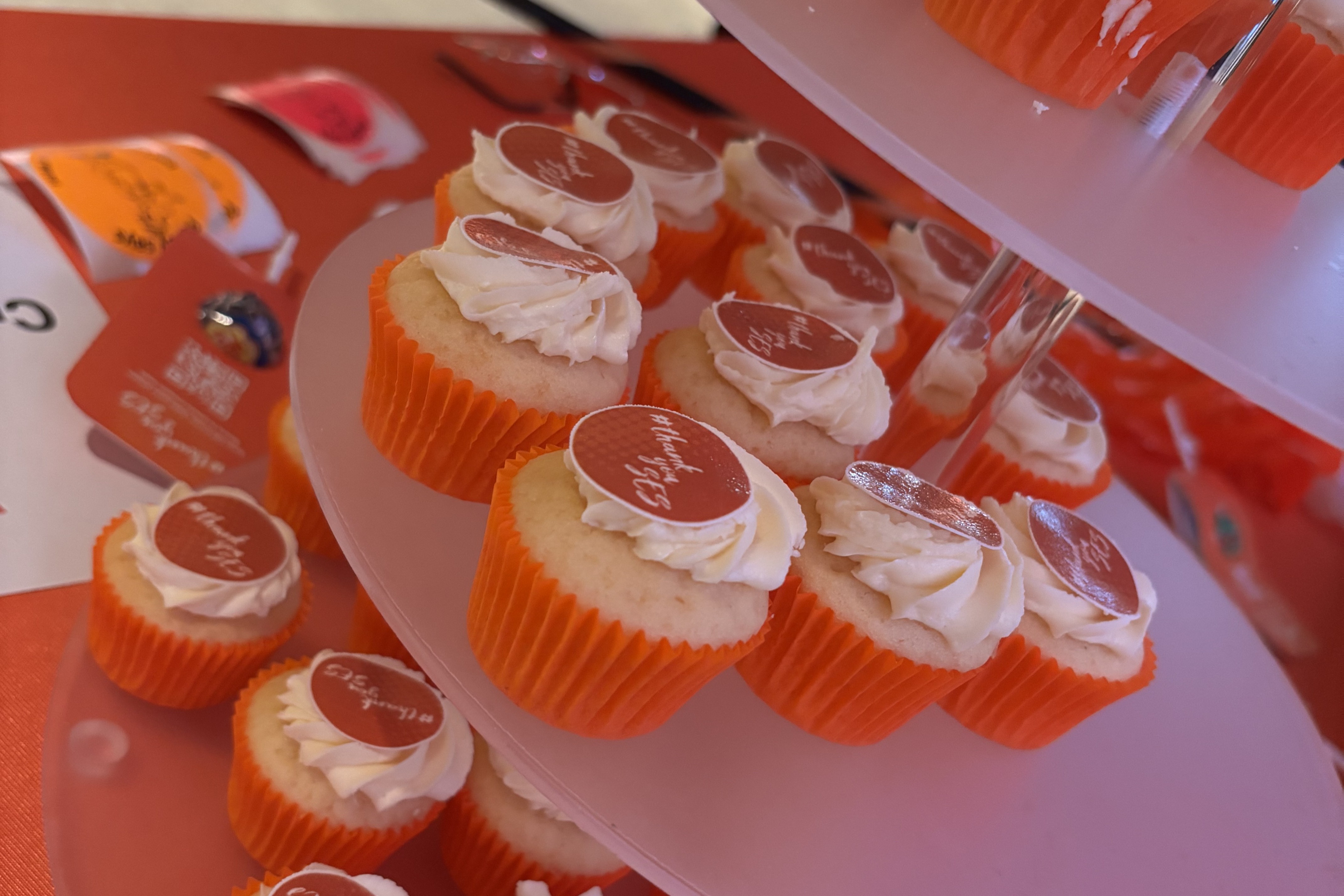 A display of cupcakes in orange cups with an orange thankyou on each.