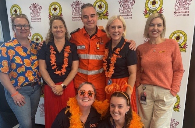 SES staff in a group photo, wearing orange.