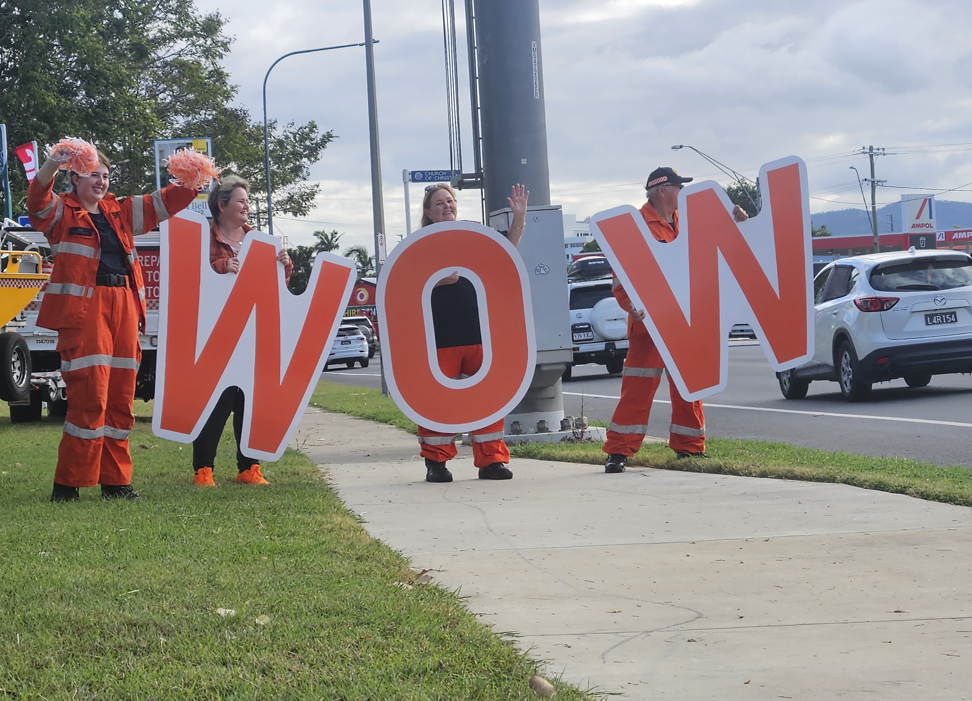SES volunteers holding WOW letters on roadside.