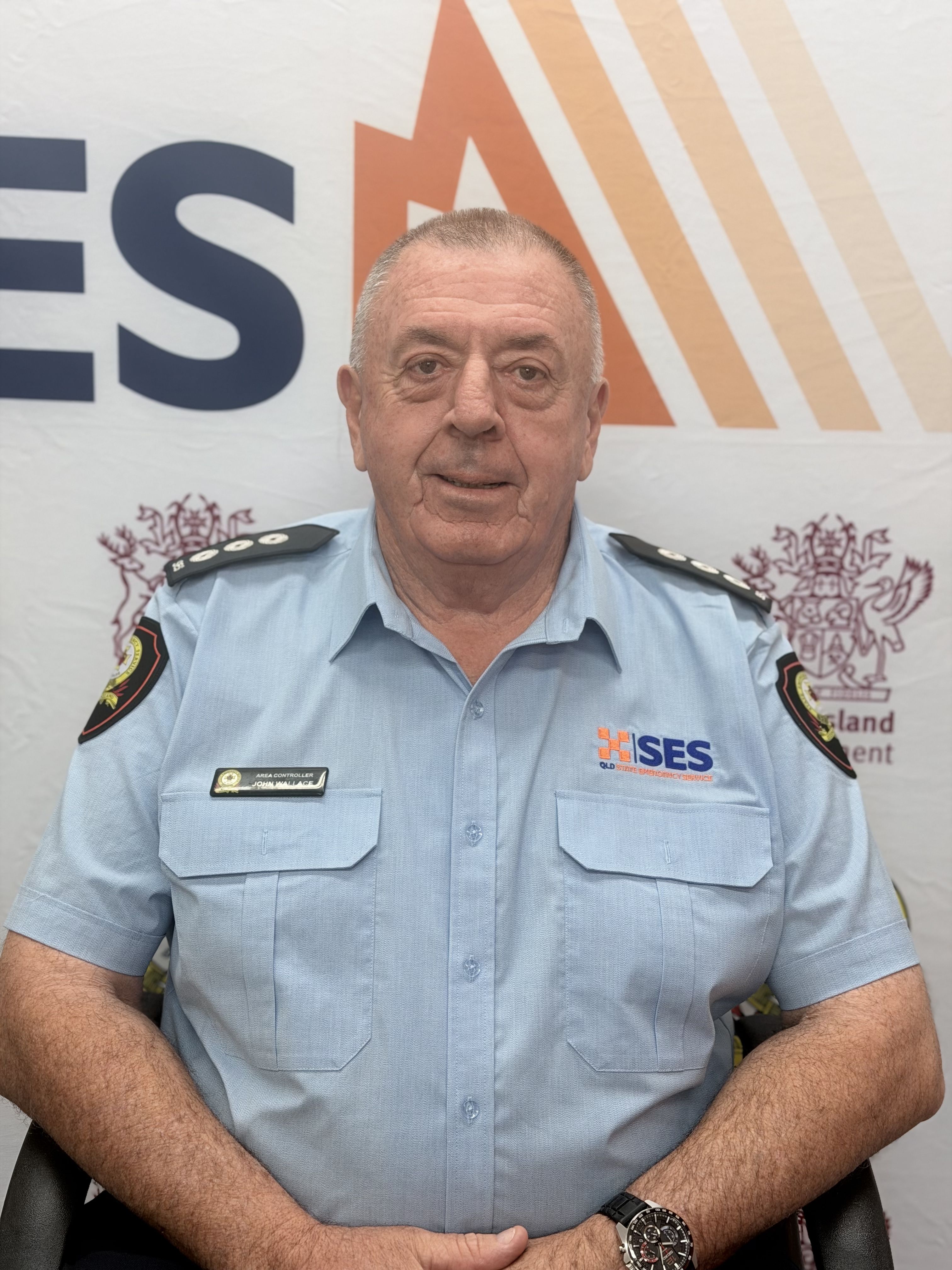 SES member John sitting in portrait style against SES background.
