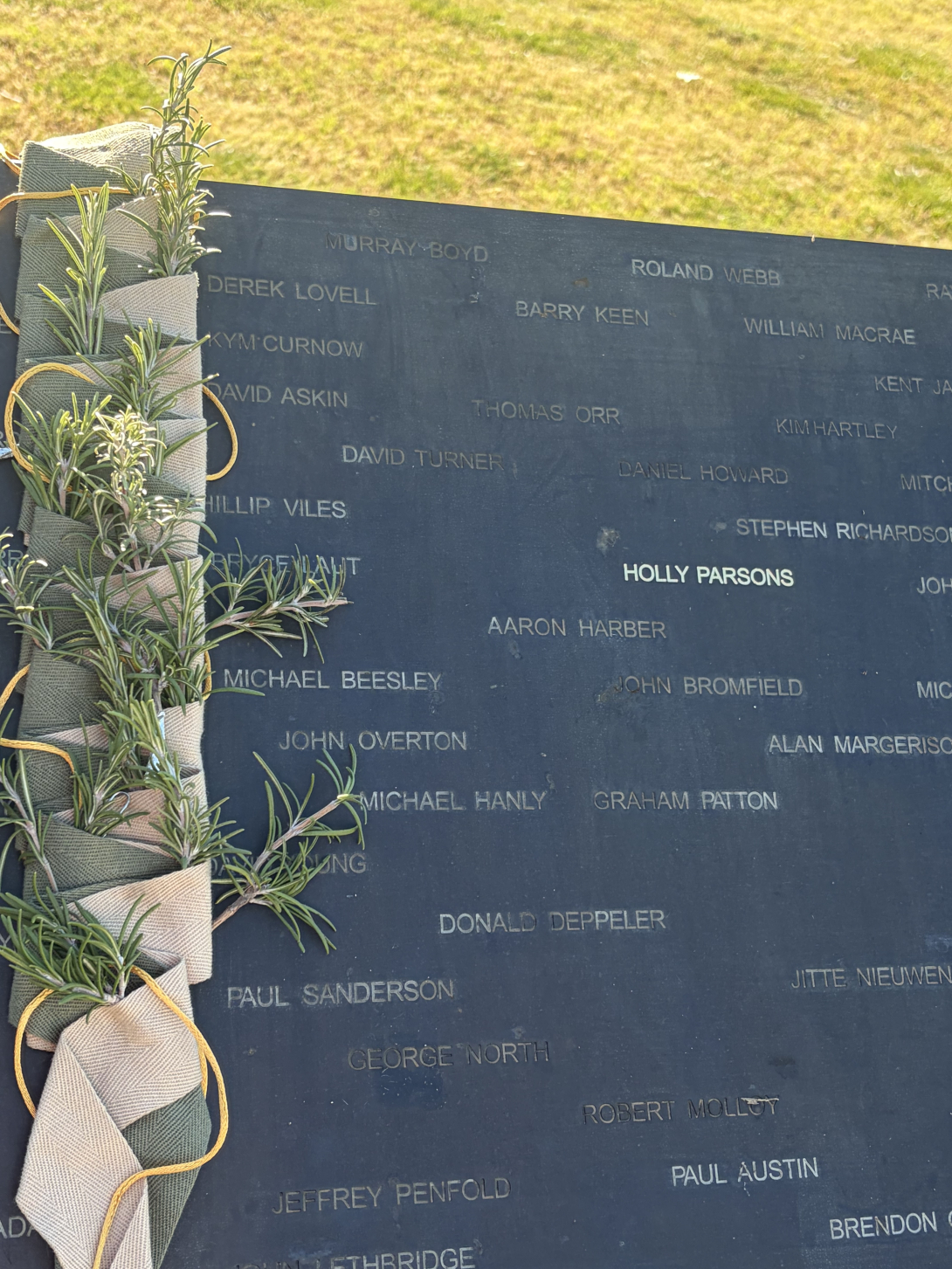 Holly Parsons name written among many others on the National Emergency Services Memorial honour roll. Sprigs of rosemary down the left.